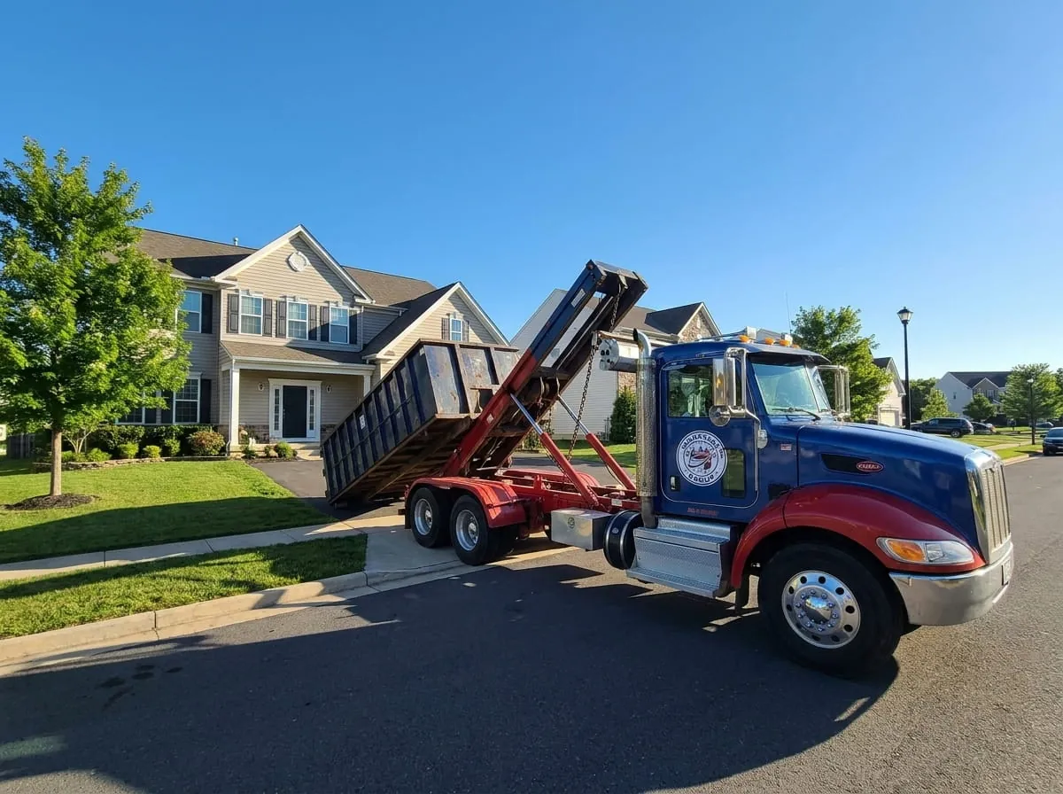Manassas Dumpster Rental Group truck delivering a roll-off dumpster to a Manassas VA driveway